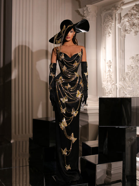 a black evening gown featuring a hat and butterfly details